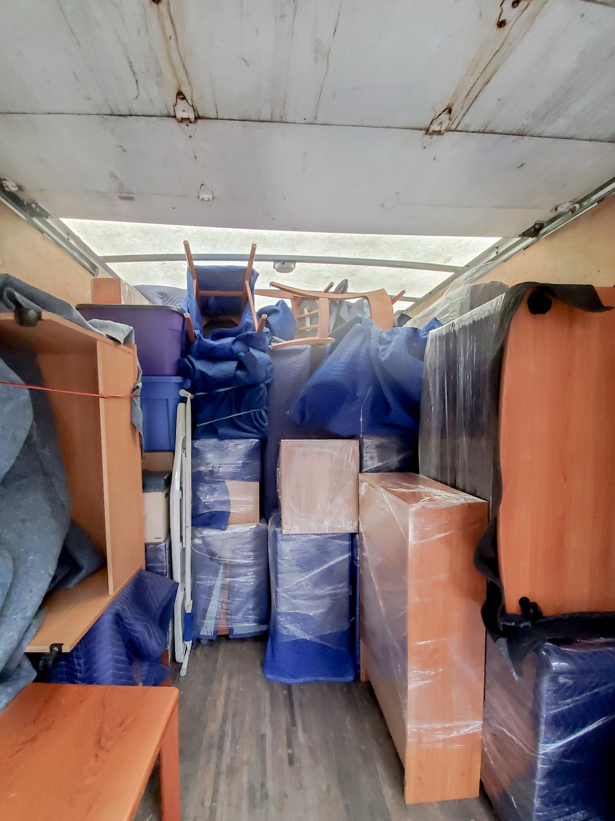 Rainbow Movers team wrapping and protecting furniture before loading onto the truck